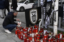 Un homme vient rendre hommage aux sept fans du PAOK tués au lendemain de l'accident survenu en Rouamanie, le 28 janvier 2026 devant le stade de Toúmba à Thessalonique.