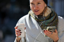 Une femme tient sa tasse de café en marchant dans les rues de New York, le 16 octobre 2025