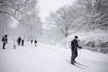 Les gens marchent et font du ski dans Central Park alors que les conditions de blizzard persistent à New York, aux États-Unis, le 23 février 2026. Les cumuls de neige atteignent plus de 48 cm à New York.