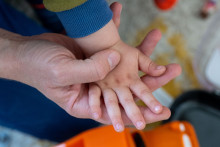 Un parent tient la main de son enfant qui est en train de jouer (image d'illustration).