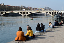 Des habitants prennent un bain de soleil sur les quais de Lyon, début mars 2026.