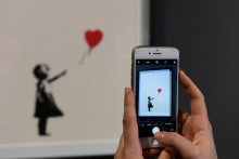 Une photo d'une sérigraphie en édition limitée de 2004 intitulée « Girl with Red Balloon » lors d'un vernissage d'une exposition sur Banksy, le 20 novembre 2018.