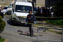 Des agents de police se rassemblent près de vêtements maculés de sang devant le consulat israélien à Istanbul, le 7 avril 2026, à la suite d'une fusillade entre des hommes armés et les forces de l'ordre.