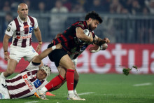 Le Toulousain Romain Ntamack plaqué par le joueur de l'UBB, Temo Matiu, devant son coéquipier Maxime Lucu, le 22 mars 2026 au stade Atlantique de Bordeaux lors d'une rencontre de Top 14.