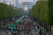 Des athlètes prennent le départ du marathon de Paris sur l'avenue des Champs-Élysées, avec l'Arc de Triomphe en arrière-plan, le 13 avril 2025.
