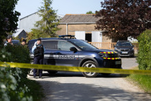 Des gendarmes se tiennent derrière un cordon à la ferme où travaillait Manon Relandeau, une mère de 31 ans portée disparue avec son bébé, à Saint-Étienne de Montluc, dans l'ouest de la France, le 21 avril 2026.