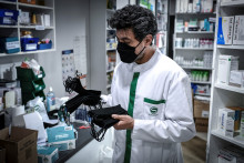 Un pharmacien tenant des masques dans ses mains, en avril 2020.