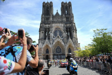 Des cyclistes passent devant la cathédrale Notre-Dame de Reims au départ de la quatrième étape de la 106e édition du Tour de France, entre Reims et Nancy, dans l'est de la France, le 9 juillet 2019