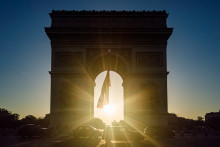 Le soleil se couche derrière l'Arc de Triomphe à Paris (Illustration).
