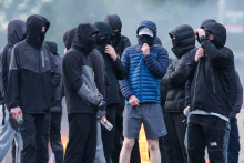 Des jeunes cagoulés bloquent une route à Belfast, en Irlande du Nord, le 9 juin 2026, après des appels à des manifestations anti-immigration en raison d'une agression par un suspect soudanais.