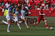 Le milieu de terrain canadien Liam Millar, s'élance avec le ballon, suivi par le défenseur bosno-herzégovinien, Nikola Katic, à Toronto, le 12 juin 2026.
