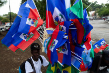 Un homme tient des drapeaux d'Haïti