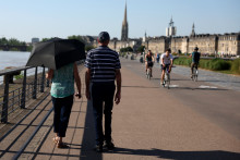 Un piéton se promène avec un parapluie sur les quais de Bordeaux, dans le sud-ouest de la France, le 17 juin 2026