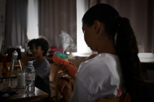 Une fillette se rafraîchit à l'aide d'un ventilateur portable dans une école primaire pendant une vague de chaleur à Bordeaux, le 1er juillet 2025.