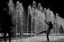 Une fillette joue dans des jets d'eau à Strasbourg, dans l'est de la France, le 20 juin 2026, alors que la France a déclenché une alerte rouge canicule sur plus d'un tiers du territoire.