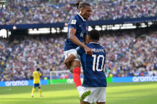 Michael Olise saute dans les bras de Kylian Mbappé lors de France-Suède en seizièmes de finale de la Coupe du monde, le 30 juin 2026 à East Rutherford.