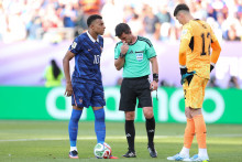 Kylian Mbappé consulte l'arbitre Ilgiz Tantashev avant de placer le ballon pour un penalty, sous le regard d'Orlando Gill du Paraguay, lors du match des huitièmes de finale de la Coupe du monde opposant le Paraguay à la France le 4 juillet 2027.
