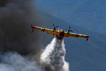Un avion Canadair CL-415 des services de sécurité civile français largue de l'eau sur un incendie de forêt au col des Auzines, près de Trevillach, dans le sud de la France, le 5 juillet 2026.