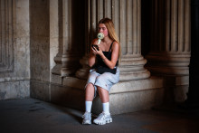 Une touriste utilise un mini-ventilateur à proximité du musée du Louvre, à Paris, lors d'un épisode de fortes chaleurs, le 24 juin 2026.
