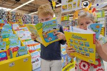 Des enfants feuillettent des cahiers de vacances à Englos (Nord), le 9 juillet 2013.