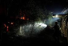 Un agriculteur arrose la forêt de Fontainebleau, au sud-est de Paris, après un incendie qui s'est déclaré en fin d'après-midi à Noisy-sur-École le 12 juillet 2026.
