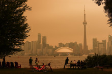 Des habitants contemplent l'horizon du centre-ville depuis les îles de Toronto, alors que les feux de forêt du nord de l'Ontario provoquent une mauvaise qualité de l'air au-dessus de la ville, à Toronto, en Ontario, au Canada, le 15 juillet 2026.