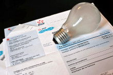 Une ampoule posée sur une facture d'électricité (EDF). (Illustration)