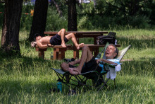 Des gens se reposent dans un parc par une journée chaude à Tokyo, le 22 juillet 2026.