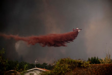 Un avion VH-8SM Aerotech largue de l'eau sur une zone en feu lors d'un incendie de forêt près de Lège-Cap-Ferret, en Gironde, le 23 juillet 2026.