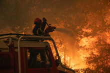 Cette photo, fournie par le SDIS33 et prise le 24 juillet 2026, montre des pompiers français tentant d'éteindre un incendie de forêt près de Saumos et de Sainte-Hélène, au nord-ouest de Bordeaux, dans le département de la Gironde.