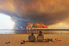 Un couple à la plage, devant l'incendie massif en Gironde
