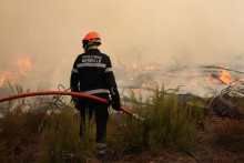 Un pompier de Marseille observe l'incendie à Arès (Gironde), le 26 juillet 2026