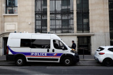 Un policier se tient aux côtés de véhicules de police et de sécurité privée devant l'immeuble de la Bank of America, dans le 8e arrondissement de Paris, le 28 mars 2026.