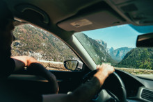 Un homme dans sa voiture sur une route en été. (Illustration)