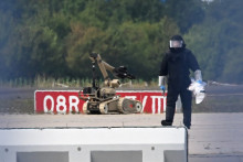 Un technicien médico-légal travaille aux côtés d'un robot de déminage près d'un avion cargo ukrainien à l'aéroport de Leipzig/Halle à Schkeuditz, dans l'est de l'Allemagne, le 5 août 2026.