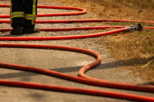 Un pompier se tient à côté d'une lance à incendie lors d'un feu de forêt près de Marcheprime, à une trentaine de kilomètres de Bordeaux, le 26 juillet 2026.