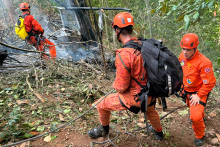 Des pompiers à l'œuvre pour éteindre un incendie après le crash d'un hélicoptère — ayant causé la mort de quatre personnes — dans le parc national de Tijuca, à Rio de Janeiro (Brésil), le 8 août 2026.