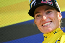 Demi Vollering célèbre sa victoire sur le podium, vêtue du maillot jaune de leader du classement général, après la 8e étape de la 5e édition du Tour de France féminin, le 8 août 2026.
