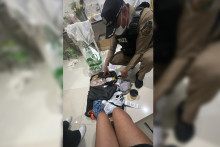 Un policier thaïlandais fouille les bagages personnels d’une Française piégée par le "plan Thaïlande" en août 2026.