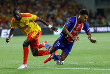 L'attaquant sénégalais de Lens Abdallah Sima tacle l'attaquant français du PSG, Désiré Doué, lors du match de Trophée des champions opposant le RC Lens au Paris Saint-Germain (PSG), le 16 août 2026.