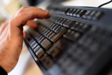 Un homme écrivant sur un clavier d'ordinateur