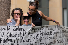 Des Américaines tenant une pancarte avec les noms d'enfants qui se sont suicidés, alors que se tient le procès historique contre Meta en Californie