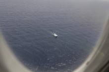Un chalutier en mer pris en photo au travers du hublot du Falcon 50 de la Marine nationale.
