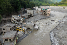 Une vue aérienne montre un torrent d'eau boueuse déferlant sur les maisons et traversant la rivière Trishuli à Betrawati, dans le district de Nuwakot au Népal, le 29 août 2026, après des crues soudaines.