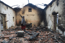 000_C6PJ8T8Une femme inspecte sa maison endommagée après qu'elle a été ravagée par un incendie de forêt à Bordj T'har, ville et commune de la province de Jijel, dans le nord-est de l'Algérie, le 27 août 2026.