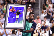 Le Français Gaël Monfils brandit une affiche encadrée qu'il a reçue en cadeau après son match du deuxième tour du simple messieurs contre l'Américain Learner Tien, le 3 septembre 2026 à l'US Open.