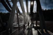 Des piétons traversent des jets d'eau sur la place Bellecour lors d'une vague de chaleur à Lyon, le 2 septembre 2026.