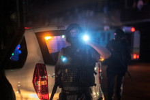 Un policier sud-africain de Johannesburg oriente sa torche lumineuse lors d'une opération.