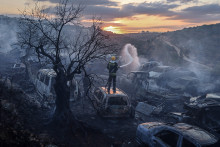 Un pompier de la défense civile palestinienne éteint un incendie qui a ravagé des voitures et des oliviers, à la suite d'une attaque qui aurait été perpétrée par des colons israéliens dans le village d'Ayn Yabrud le 4 octobre 2026.
