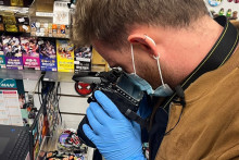 Un technicien de la police scientifique recherchant des preuves dans une boutique saccagée lors des violences du 17 octobre